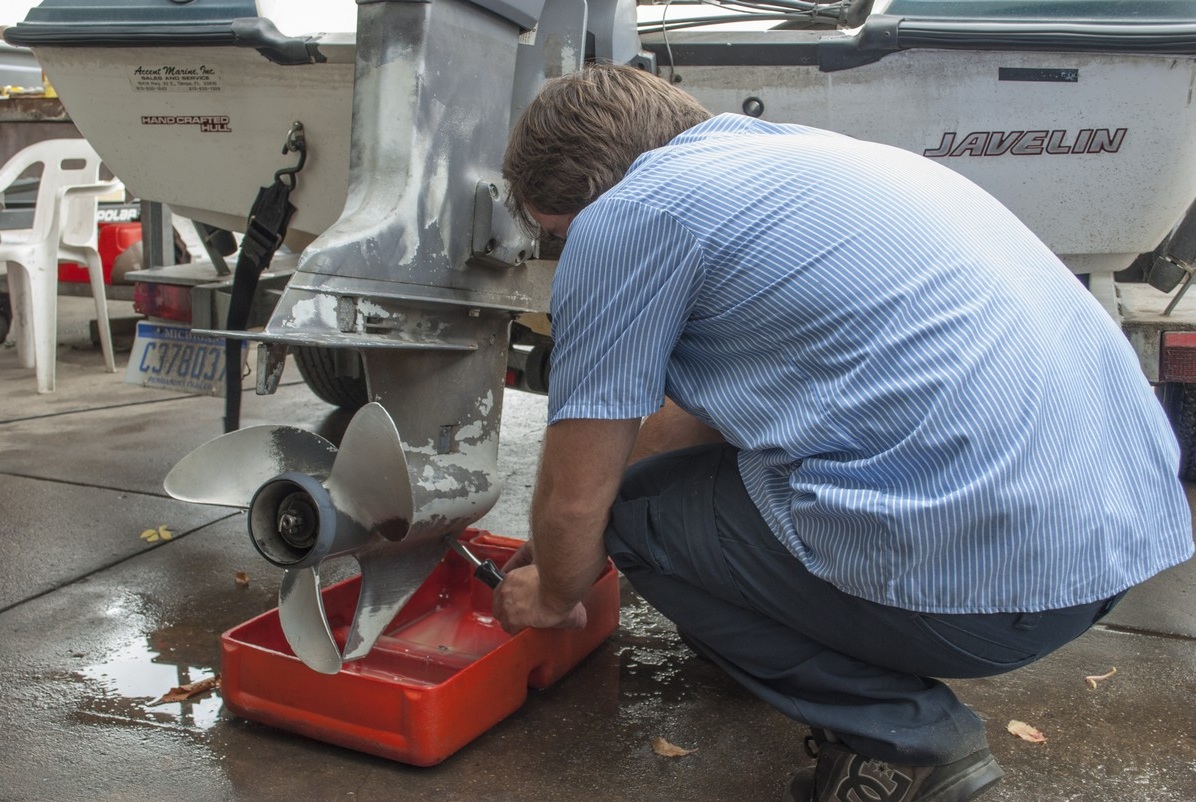 Dieser Mechaniker demonstriert das Lösen der Ablassschraube für den Wechsel des Getriebeöls.